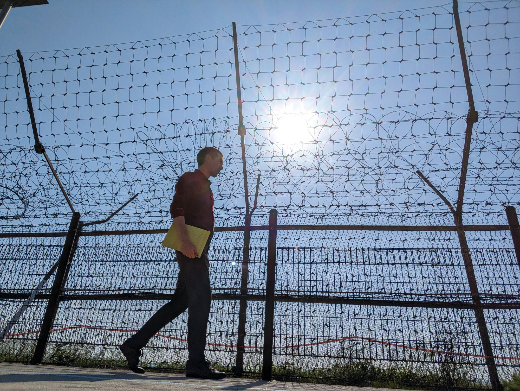 Tim Huber, Anabaptist World associate editor, walks by military fencing along the shore of Gyodong Island, South Korea, on June 1.